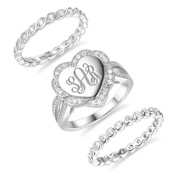 Crystal-encrusted sterling silver ring with heart-shaped monogram and dual stackable bands.