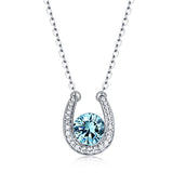 Silver horseshoe pendant necklace with a central blue birthstone surrounded by sparkling crystals on a chain.