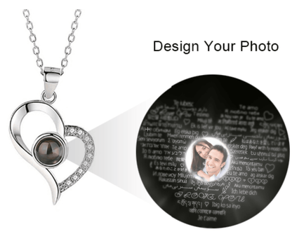 Silver heart-shaped pendant necklace with a central black gemstone, small clear crystals on one side, and customizable photo and text inside the gemstone.