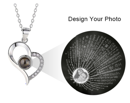 Silver heart-shaped pendant necklace with a central black gemstone, small clear crystals on one side, and customizable photo and text inside the gemstone.