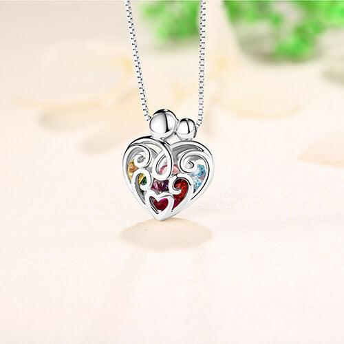 Silver heart pendant with vibrant, multicolored gemstones on a silver chain, with a soft background.