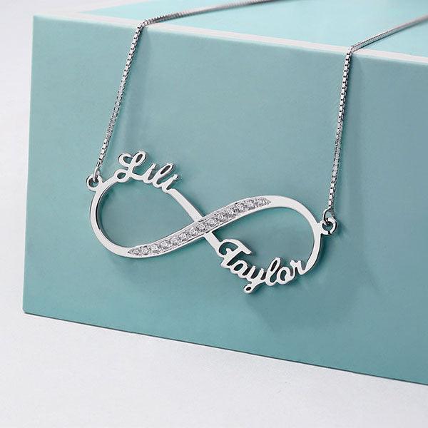 Personalized Infinity Necklace with Sparkling Diamonds in Sterling Silver 925, featuring the names "Lili" and "Taylor," displayed on a blue gift box.