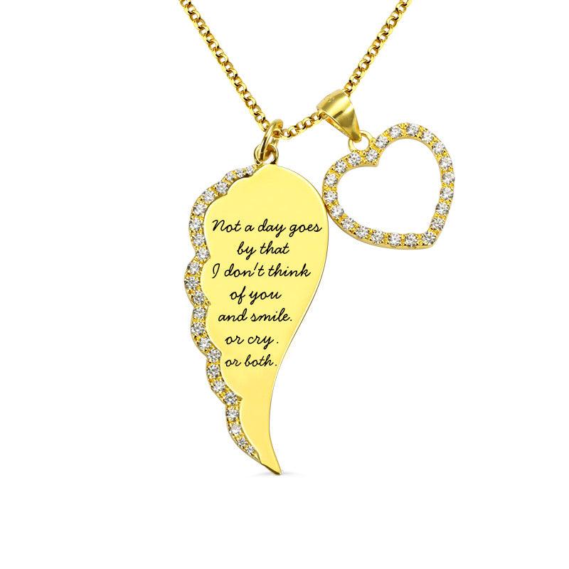 Gold pendant necklace with a wing-shaped charm and a heart encrusted with rhinestones, featuring a poignant quote