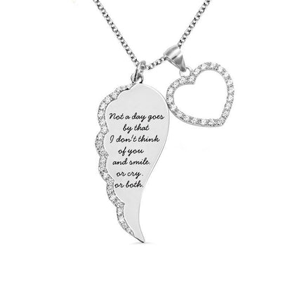 Silver pendant necklace featuring a wing-shaped charm with rhinestones and a heart, with an emotional quote engraved.