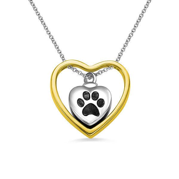 Silver and gold heart-shaped pendant with a black paw print, suspended on a silver chain.
