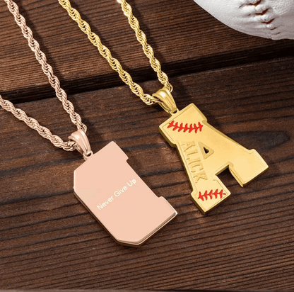Two personalized baseball-themed pendants on rope chains: a rose gold "D" with "Never Give Up" engraved on the back, and a gold "A" with red stitching and the name "Alick" engraved.