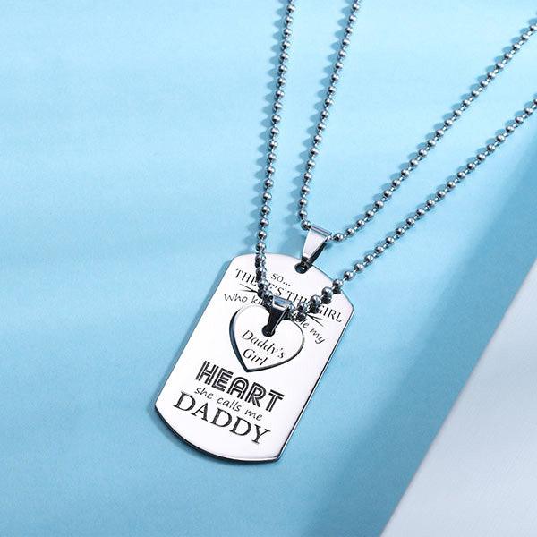 Silver dog tag and heart pendant reading "Daddy's Girl" and "she calls me DADDY," displayed on a blue background.