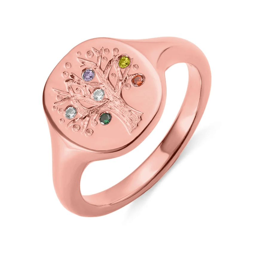 Rose gold ring with a family tree motif and multicolored gemstones on white.