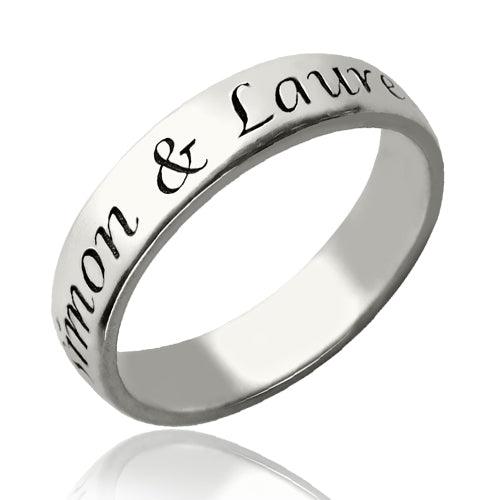 A silver ring engraved with the names "Simon & Lauren" in elegant script, shown on a white background. The ring has a polished, reflective finish.