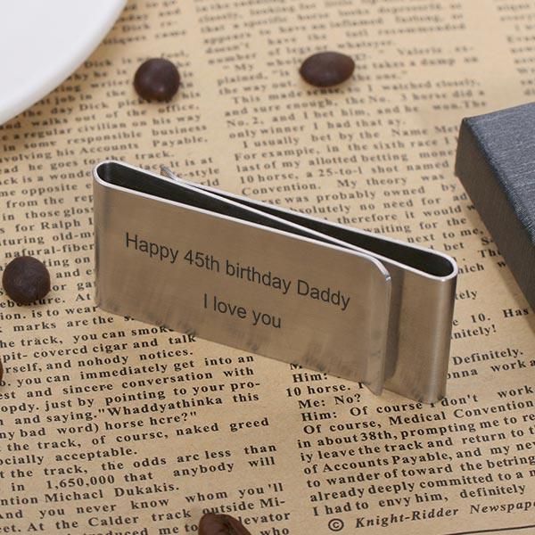 Reflective money clip on newspaper with 'Happy 45th birthday Daddy I love you' engraved