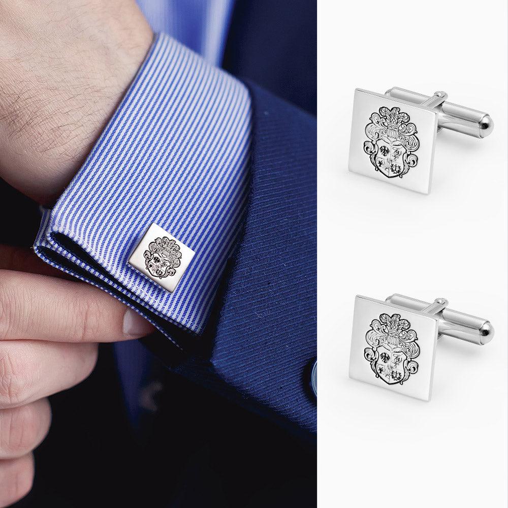 Cufflink with intricate crest design on a striped blue dress shirt sleeve; separate close-up of the matching cufflink.
