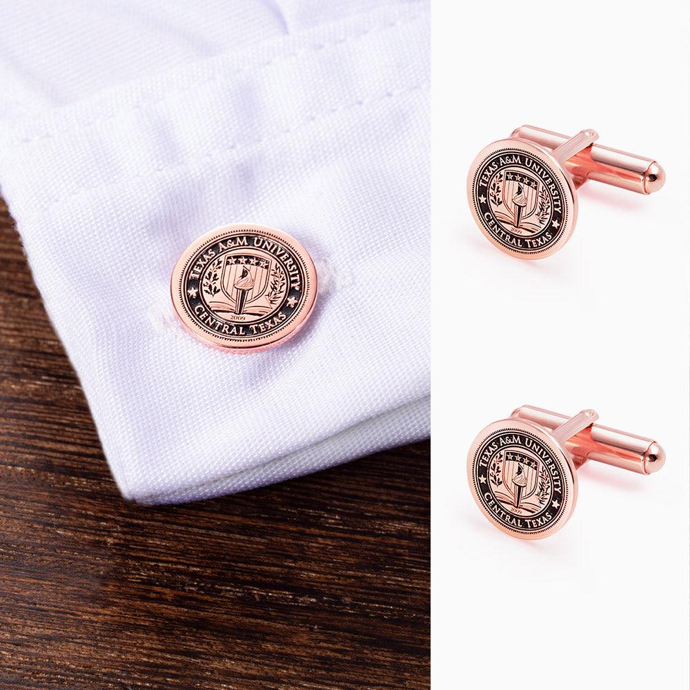 Rose gold cufflink with university seal on a white shirt; close-up view included.