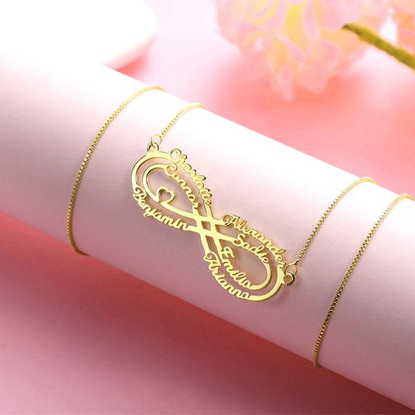 Gold infinity necklace personalized with names displayed on a pink background.