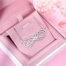 Custom engraved silver infinity necklace in a pink gift box with soft fabric interior.