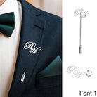 Man in a suit with a monogrammed 'RH' silver lapel pin and a green pocket square.