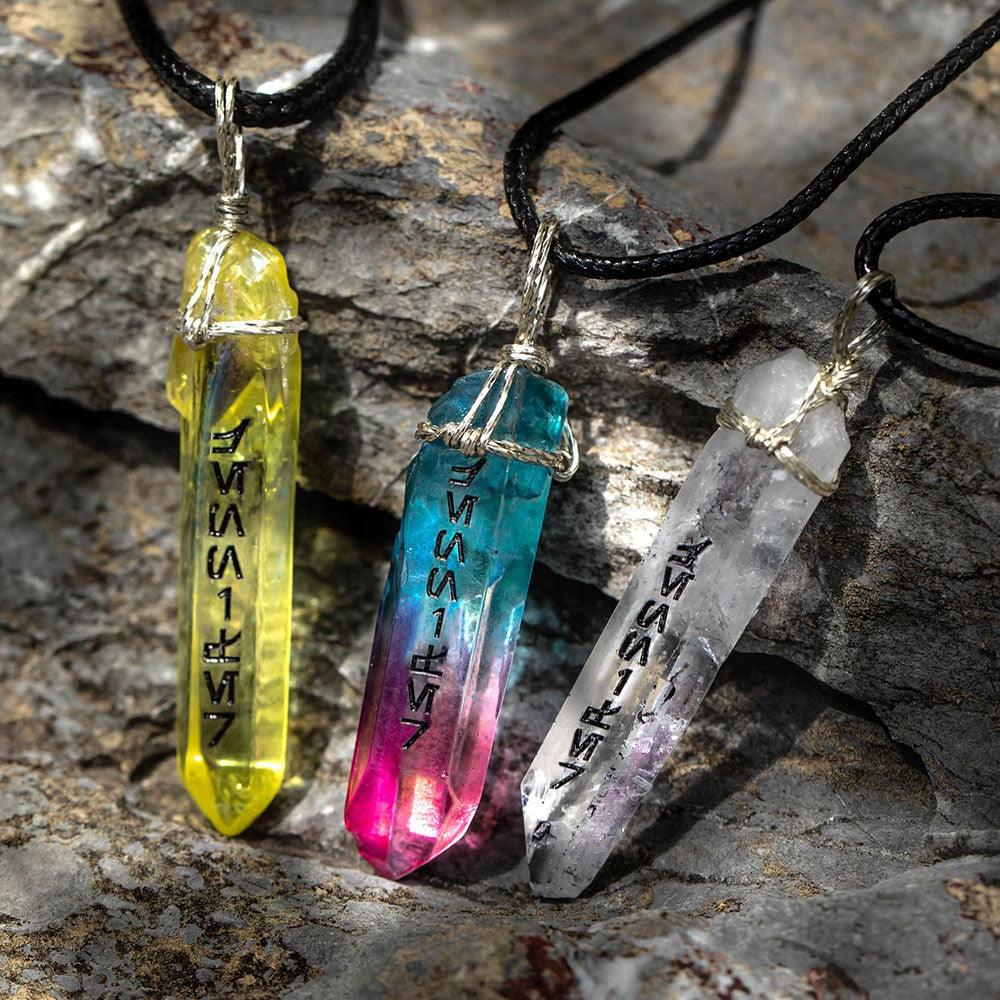 Colorful kyber crystal necklaces with black cords on a natural stone surface.