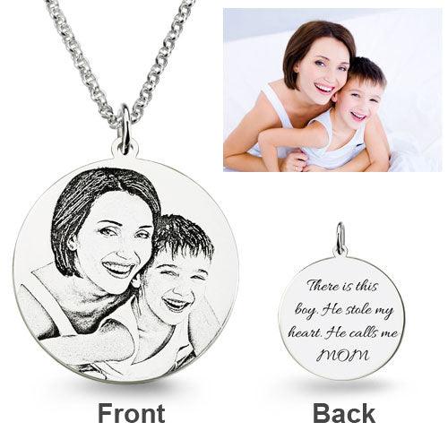 A round silver pendant necklace features an engraved photo of a smiling mother and son on the front. The back is inscribed with, "There is this boy. He stole my heart. He calls me MOM."