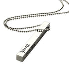 Silver bar pendant on a ball chain necklace engraved with the names "Derek" on one side and "Shawn" on the other.