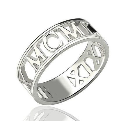 A sculpted cut-out style ring in silver featuring intricate Roman numerals, with "MCM" and "XIX" prominently displayed in the design.