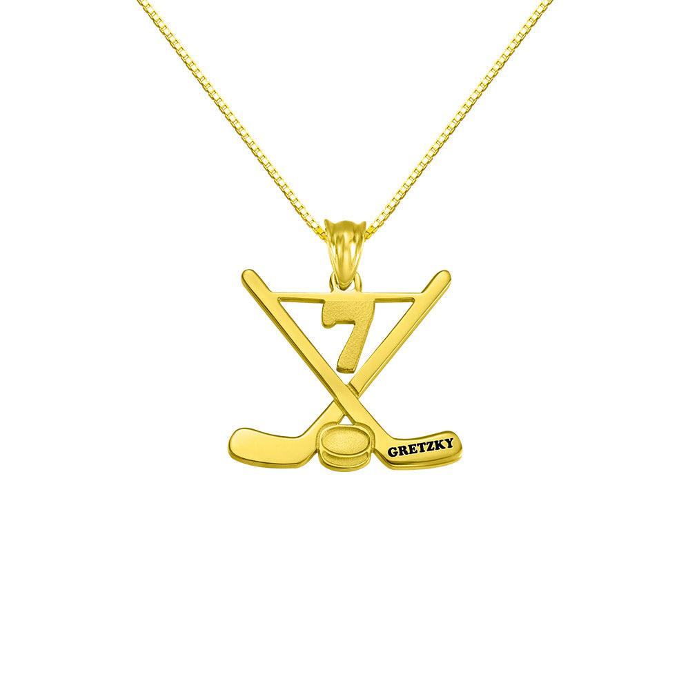 Gold hockey-themed necklace with crossed sticks, a puck, and the name "Gretzky" with the number 7 above.