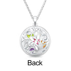 Back view of a silver necklace with a circular pendant featuring an intricate tree design and multicolored gemstones embedded within the branches.