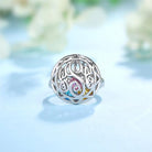 Silver ring with a detailed Celtic knot design and colorful heart-shaped birthstones inside.