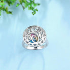 Silver Celtic knot ring with a colorful eye-shaped gemstone at the center.