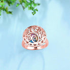 Rose gold Celtic knot ring with a central, colorful eye-shaped gemstone.