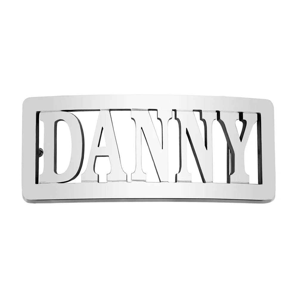 Rectangular silver belt buckle with 'DANNY' in bold uppercase letters, cut through the metal, isolated on a white background.