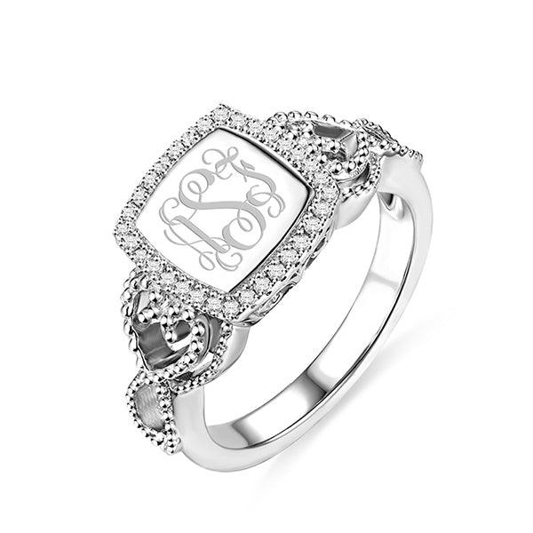 Silver monogram ring with an engraved 'ASJ' design, surrounded by a halo of small diamonds and ornate side details.