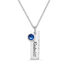 Hammered personalized birthstone bar charm necklace in pure silver with the name "Katniss" and a blue gemstone on a silver chain.