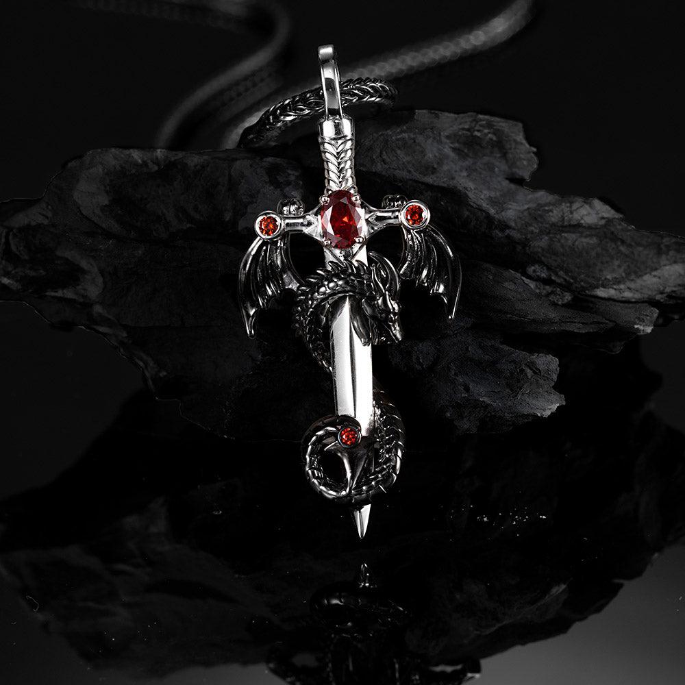 Gothic dragon and sword pendant with red birthstones on a twisted silver chain.