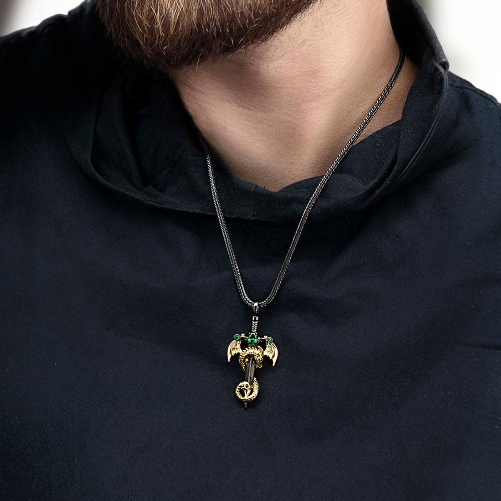 Man in black shirt with gold and green dragon sword necklace on a silver chain.