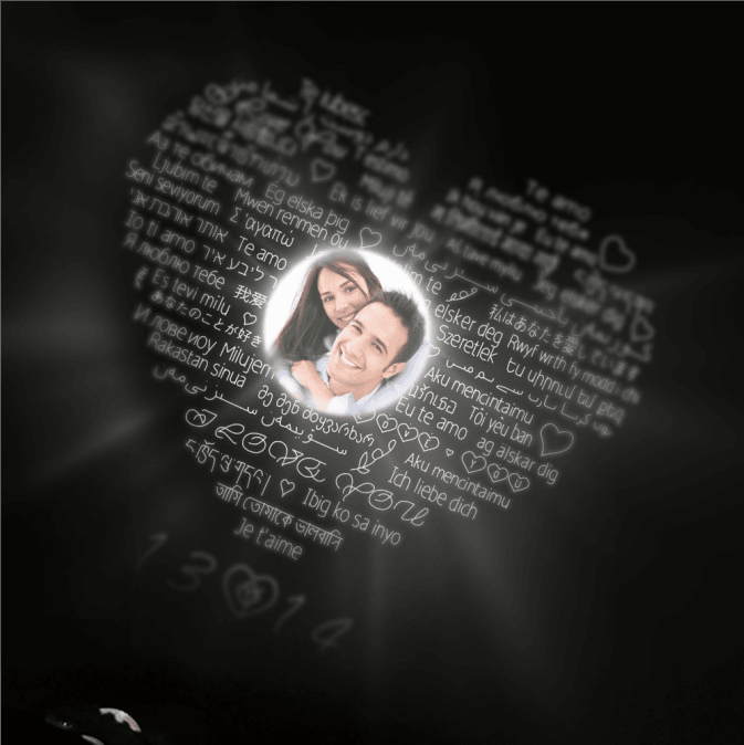 Heart-shaped projection with "I love you" in various languages surrounding a central photo of a happy couple, illuminated against a dark background.