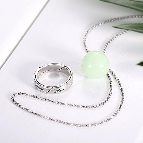 Sterling Silver Luminous Stone Pendant Necklace and Ring, featuring a glowing green gemstone and personalized engravings, displayed on a white background