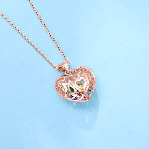 Rose gold open heart pendant with "Mom" inscribed, featuring colorful birthstones inside, on a box chain necklace against a light blue background.