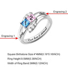 A silver ring featuring two colorful gemstones, each numbered, and engraved names corresponding to each stone, along with size specifications at the bottom. The ring includes the engraving "Our love is eternal."