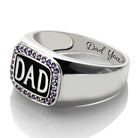 Silver ring featuring "DAD" framed by purple gems, with "Dad You" engraved on the side.