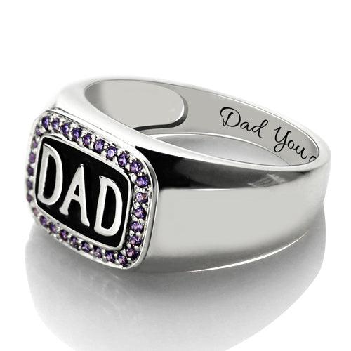 Silver ring featuring "DAD" framed by purple gems, with "Dad You" engraved on the side.