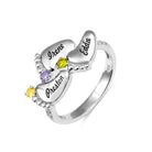 A silver ring featuring four engraved baby feet with names "Irene," "Eddie," "Preston," and "Amber," adorned with colorful gemstones, symbolizing "Always in my heart."