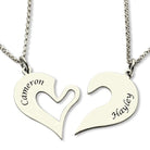 Two silver pendants forming a split heart, each with a name engraved. The left pendant reads "Cameron," and the right pendant reads "Hayley," each on separate chains.