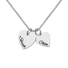 A silver necklace with two heart-shaped pendants, one engraved with "Sarah" and the other with "Chloe."