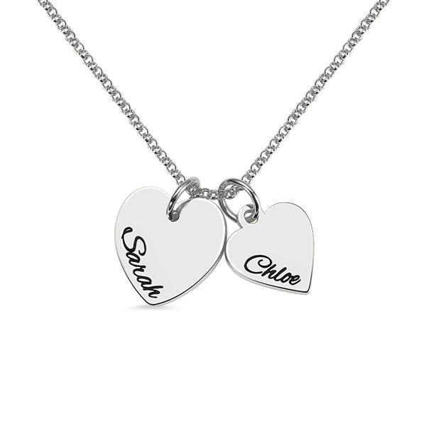 A silver necklace with two heart-shaped pendants, one engraved with "Sarah" and the other with "Chloe."