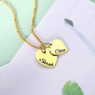 A gold necklace with two heart-shaped pendants, one engraved with "Sarah" and the other with "Chloe," displayed on a pastel green and white background.