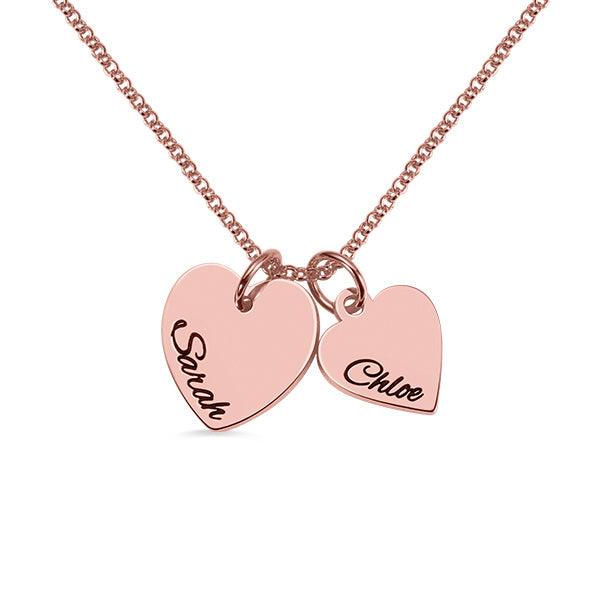 A rose gold necklace with two heart-shaped pendants, one engraved with "Sarah" and the other with "Chloe," on a white background.