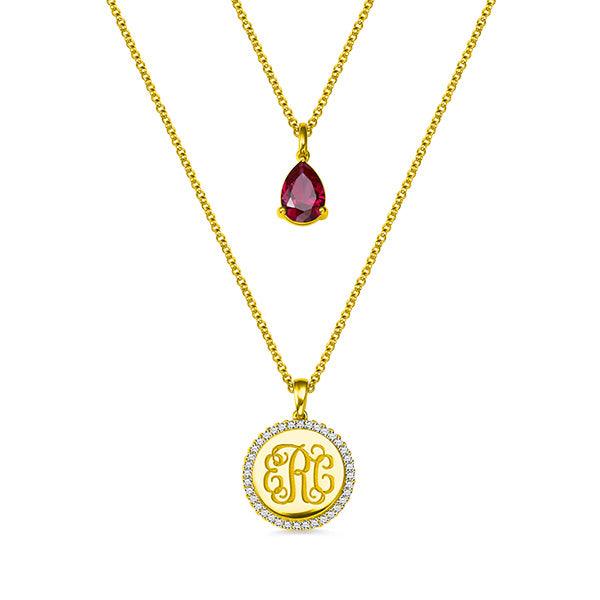 Double-layered necklace in gold with a teardrop birthstone pendant and CZ monogram pendant, ideal for personalized gifts and special occasions.