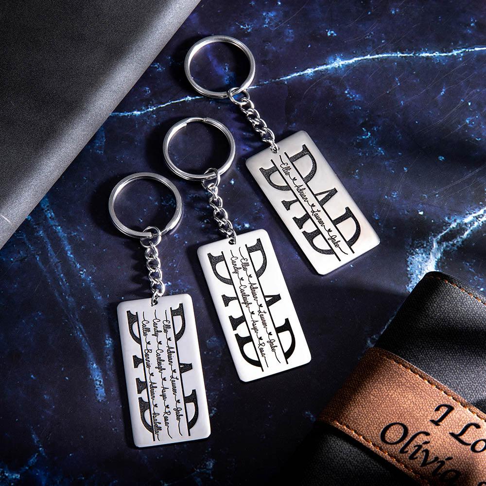 Three "DAD" keychains with personalized names on a dark, starry background.