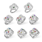 Eight silver rings with heart and floral designs, each featuring colorful gems and engraved names like "Love you forever," "My family, my world," and "We love you mama."