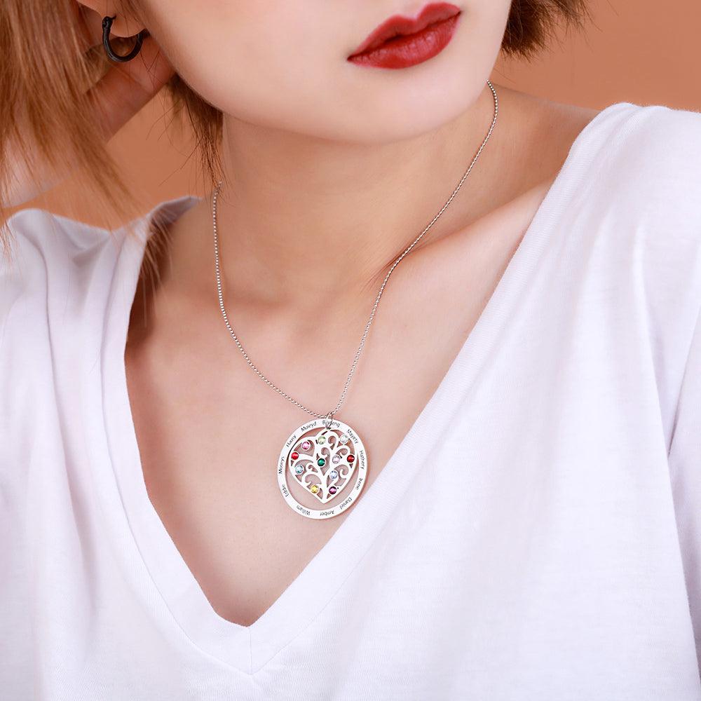 Woman wearing a silver family tree necklace with colorful gemstones.