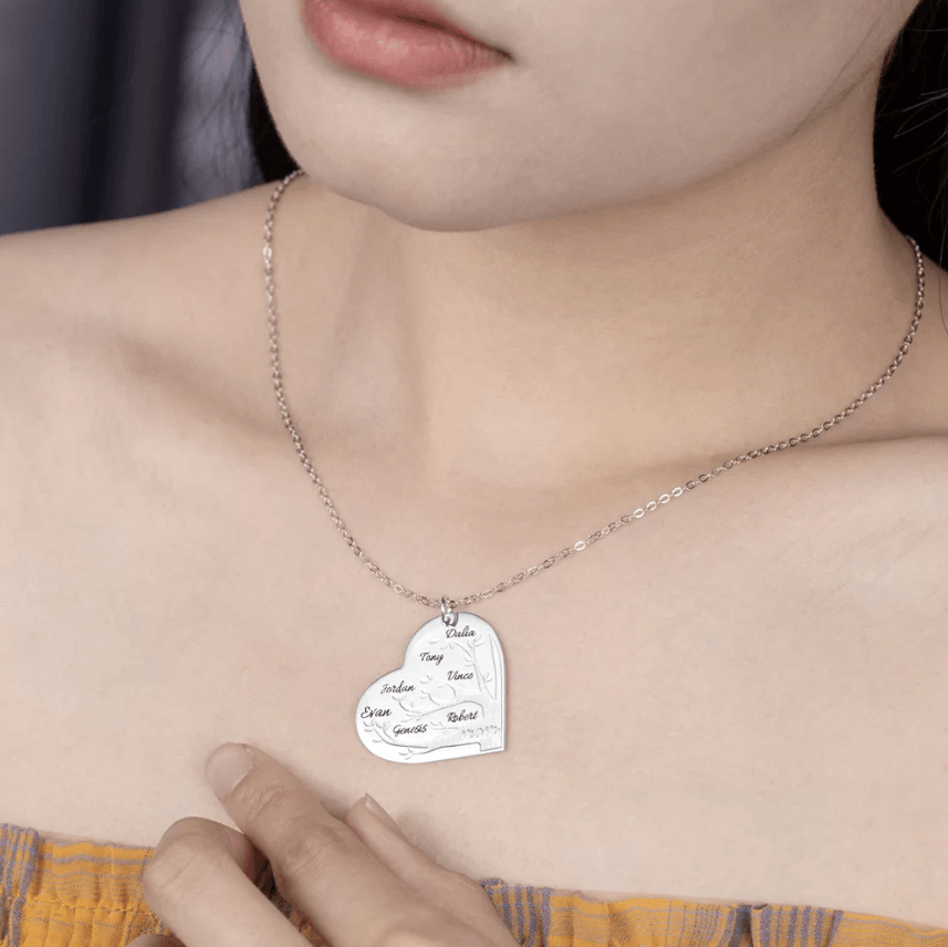 Woman wearing a silver heart-shaped pendant necklace with a family tree design, featuring names Dalia, Tony, Vince, Jordan, Evan, Genesis, Robert, and "mom" at the bottom.